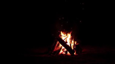 Karanlık Orman 'da Kara Orman' da Gece Ateşi Yanıyor. Ağır çekim. Gece vakti Alevli Kamp Ateşi. Şenlik Ateşi için yer. Ateş Çukuru, Ateş Altında Orman, Uçan Kıvılcımlar ve Duman - Statik Atış