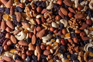Karışık fındık, badem, ceviz, kaju, fıstık, fındık, kuru erik ve kuru üzüm. Farklı fındık karışımı. Çeşitli Fındık ve Kurutulmuş Meyvelerin Arkaplanı