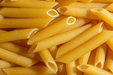 Pişmemiş Penne Rigate Makarnası: Gurme Aşçılık İçin Canlı ve Dokulu Bir Arkaplan Oluşturan Penne Makarna Mutfağı. Kuru makarna. Raw Macaroni - Top View, Düz Yat