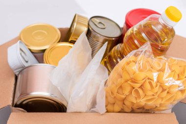 Bağış Kutusu Bedava Yemek. İçinde konserve yiyecek, mısır gevreği ve market olan bir karton kutu. Yemek rezervleri. Kriz anında acil durum gıda deposu. Ücretsiz Sosyal Yardım, Lütuf ve Bakım. Stratejik Gıda Malzemeleri