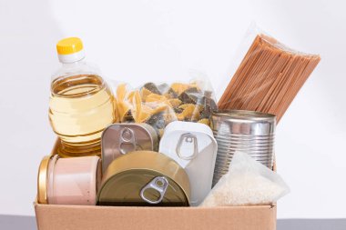 Bağış Kutusu Bedava Yemek. İçinde konserve yiyecek, mısır gevreği ve market olan bir karton kutu. Yemek rezervleri. Kriz anında acil durum gıda deposu. Ücretsiz Sosyal Yardım, Lütuf ve Bakım. Stratejik Gıda Malzemeleri