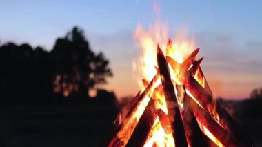 Blue Sky 'a karşı Yaz Gecesinde Büyük Yanan Kamp Ateşi. Ateşe odun. Uçan Kıvılcım. Seyahat ve Turizm Konsepti. Dev Alevli Şenlik Ateşi - Statik Çekim, Yavaş Hareket