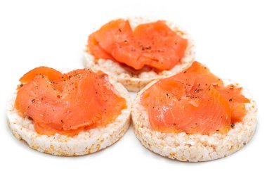 Beyaz üzerine taze somon dilimli Lezzetli Pirinçli Sandviç. Kolay Kahvaltı ve Diyet Yemekler. Kırmızı balıklı çıtır ekmek. Sağlıklı Beslenme Atıştırmaları - İzolasyon