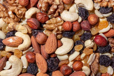 Karışık fındık, badem, ceviz, kaju, fıstık, fındık, kuru erik ve kuru üzüm. Farklı fındık karışımı. Çeşitli Fındık ve Kurutulmuş Meyvelerin Arkaplanı
