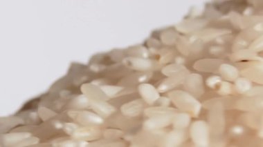 Kuru pişmemiş beyaz pirinç yığını dönüşümlü Macro. Çiğ Uzun Taneli Pirinç Yığını. Yakın plan. Asya mutfağı ve kültürü. Sağlıklı beslenme malzemeleri. Diyet Yemekler