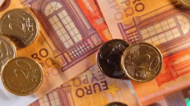 50 Euro 'luk banknotlara 20 Euro Cent madeni parası - Top View. Euro Para Birimi. Turuncu Kağıt Para. Bir sürü 20 Euro 'luk banknot. İş, Finans, Para ve Tasarruf Konsepti - Yavaş Dönüşüm Sağı