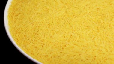Raw Uncooked Noodles on White Plate Rotating against Black Background. Dry Vermicelli Turning Around. Raw Pasta