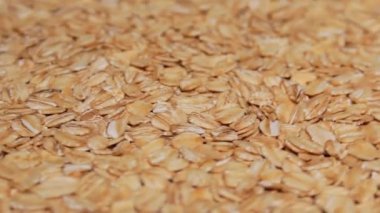 Uncooked Oat Flakes Rotating. Scattered Dry and Raw Oat Flakes. Healthy Breakfast and Diet Eating Ingredients