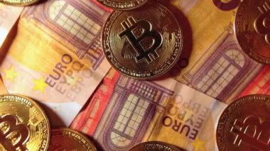 50 Euro 'luk banknotlarda Bitcoin Sikkeleri - Top View. Euro Para Nakiti ve Kripto Para Birimi. Bir sürü 50 Euro 'luk banknot. Ekonomi, Borsa, Engelleme ve Elektronik Para Konsepti - Yavaş Döndürme Sağı