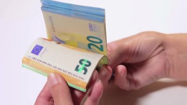 Elde Para Saymak. Avrupa Birliği Parası. Beyaz Kadın Beyaz Masa 'da Farklı Euro Banknotları Sayıyor - Yakın plan. Renkli Kağıt Para. Avro Elde. Gelir, Tasarruf ve Harcama Konsepti