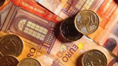 50 Euro 'luk banknotlara 20 Euro Cent madeni parası - Top View. Euro Para Birimi. Turuncu Kağıt Para. Bir sürü 20 Euro 'luk banknot. İş, Finans, Para ve Tasarruf Konsepti - Yavaş Dönüşüm Sağı