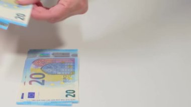 Beyaz Masa 'ya Para Saymak. Avrupa Birliği Parası. Beyaz Kadın 20 Avro Banknotları Sayıyor - Ön Manzara. Mavi Kağıt Nakit. 20 Euro Elde. Gelir, Tasarruf ve Harcama Konsepti