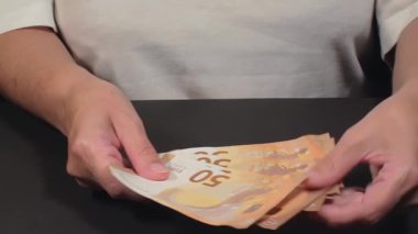 Elde Para Saymak. Avrupa Birliği Parası. Beyaz Kadın 50 Avro Banknotları Sayıyor - Ön Manzara, Yakın plan. Turuncu Kağıt Nakit. Elde Elli Euro. Gelir, Tasarruf ve Harcama Konsepti