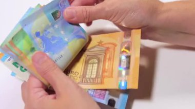 Elde Para Saymak. Avrupa Birliği Parası. Beyaz Kadın Beyaz Masa 'da Farklı Euro Banknotları Sayıyor - Yakın plan. Renkli Kağıt Para. Avro Elde. Gelir, Tasarruf ve Harcama Konsepti