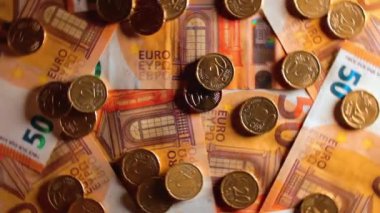 50 Euro 'luk banknotlara 20 Euro Cent madeni parası - Top View. Euro Para Birimi. Turuncu Kağıt Para. Bir sürü 20 Euro 'luk banknot. İş, Finans, Para ve Tasarruf Konsepti - Dönüşüm Sola