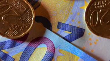 20 Euro banknotuna 20 Euro Cent madeni parası - Top View, Macro. Euro Para Birimi. Mavi Kağıt Para. Bir sürü 20 Euro 'luk banknot. İş, Finans, Para ve Tasarruf Konsepti - Yavaş Dönüşüm Sola