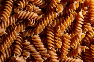 Pişmemiş Whole Grain Fusilli Makarna: Gurme Aşçılık İçin Canlı ve Dokulu Bir Arkaplan Oluşturan Tam Buğday Büfesi. Tam Tahıllı Kurutulmuş Makarna. Tam buğday hamurlu makarna.