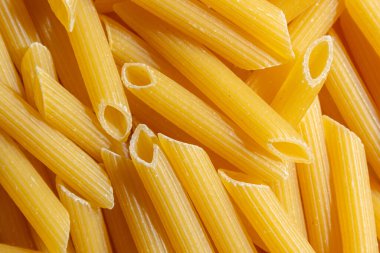 Pişmemiş Penne Rigate Makarnası: Gurme Aşçılık İçin Canlı ve Dokulu Bir Arkaplan Oluşturan Penne Makarna Mutfağı. Kuru makarna. Raw Macaroni - Top View, Düz Yat