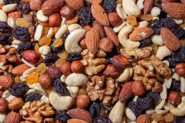 Karışık fındık, badem, ceviz, kaju, fıstık, fındık, kuru erik ve kuru üzüm. Farklı fındık karışımı. Çeşitli Fındık ve Kurutulmuş Meyvelerin Arkaplanı