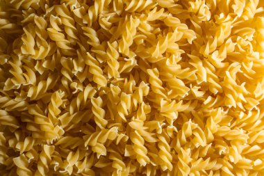 Pişmemiş Fusilli Makarna: Bir Spiral Makarna Mutfağı, Gurme Yemekleri İçin Canlı ve Dokulu Bir Arkaplan Oluşturma. Kuru makarna. Raw Macaroni - Top View, Düz Yat