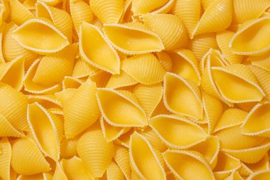 Pişmemiş Conchiglie Pasta: Konchiglie Macaroni 'nin Mutfak Tuvali, Gurme Yemekleri İçin Canlı ve Dokulu Bir Arkaplan Oluşturuyor. Kuru makarna. Raw Macaroni - Top View, Düz Yat