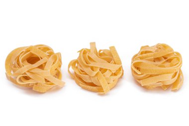 Beyaz arka planda izole edilmiş üç klasik İtalyan çiğ yumurtası Fettuccine. Kuru, bükülmemiş, pişmemiş makarna. İtalyan Kültür ve Mutfağı. Çiğ Altın Makarna Deseni - İzolasyon