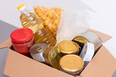 Bağış Kutusu Bedava Yemek. İçinde konserve yiyecek, mısır gevreği ve market olan bir karton kutu. Yemek rezervleri. Kriz anında acil durum gıda deposu. Ücretsiz Sosyal Yardım, Lütuf ve Bakım. Stratejik Gıda Malzemeleri