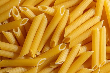 Pişmemiş Penne Rigate Makarnası: Gurme Aşçılık İçin Canlı ve Dokulu Bir Arkaplan Oluşturan Penne Makarna Mutfağı. Kuru makarna. Raw Macaroni - Top View, Düz Yat