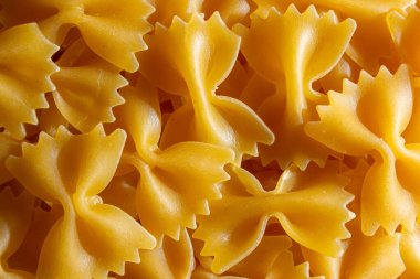 Pişmemiş Farfalle Makarnası: Gurme Aşçılık İçin Canlı ve Dokulu Bir Arkaplan Oluşturan Papyonlu Makarna Mutfağı. Kuru makarna. Raw Macaroni - Top View, Düz Yat