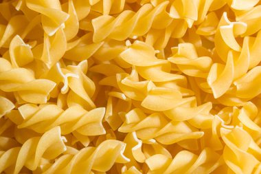 Pişmemiş Fusilli Makarna: Bir Spiral Makarna Mutfağı, Gurme Yemekleri İçin Canlı ve Dokulu Bir Arkaplan Oluşturma. Kuru makarna. Raw Macaroni - Top View, Düz Yat