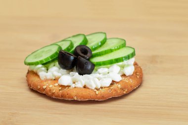 Taze salatalık, süzme peynir ve zeytinli çıtır krakerli sandviç. Diyet yemek. Kolay Kahvaltı 'da. Hızlı ve sağlıklı sandviçler. Lezzetli dolgulu kızarmış ekmek. Sağlıklı Beslenme Atıştırması