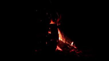 Karanlık Orman 'da Kara Arkaplan' da Gece Ateşi Yanıyor. Gece vakti Alevli Kamp Ateşi. Şenlik Ateşi için yer. Ateş Çukuru, Ateş Altında Orman, Uçan Kıvılcımlar ve Duman - Statik Atış