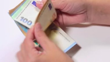 Elde Para Saymak. Avrupa Birliği Parası. Beyaz Kadın Beyaz Masa 'da Farklı Euro Banknotları Sayıyor - Yakın plan. Renkli Kağıt Para. Avro Elde. Gelir, Tasarruf ve Harcama Konsepti