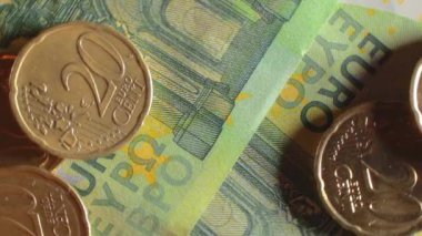 100 Euro 'luk banknotlara 20 Euro Cent madeni parası - Top View, Macro. Euro Para Birimi. Yeşil Kağıt Para. Yüz Euro 'luk banknot. İş, Finans, Para ve Tasarruf Konsepti - Yavaş Dönüşüm Sola