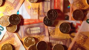 50 Euro 'luk banknotlara 20 Euro Cent madeni parası - Top View. Euro Para Birimi. Turuncu Kağıt Para. Bir sürü 20 Euro 'luk banknot. İş, Finans, Para ve Tasarruf Konsepti - Yavaş Dönüşüm Sola