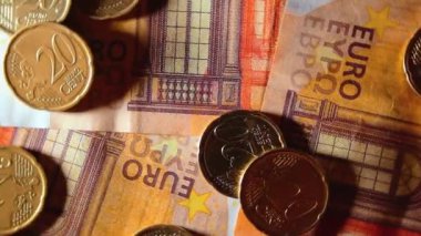 50 Euro 'luk banknotlara 20 Euro Cent madeni parası - Top View. Euro Para Birimi. Turuncu Kağıt Para. Bir sürü 20 Euro 'luk banknot. İş, Finans, Para ve Tasarruf Konsepti - Yavaş Dönüşüm Sola