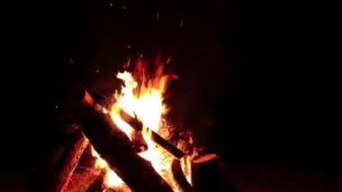 Karanlık Orman 'da Kara Orman' da Gece Ateşi Yanıyor. Ağır çekim. Gece vakti Alevli Kamp Ateşi. Şenlik Ateşi için yer. Ateş Çukuru, Ateş Altında Orman, Uçan Kıvılcımlar ve Duman - Statik Atış