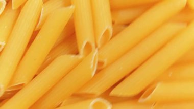 Pişmemiş Penne Rigate Pasta: Penne Macaroni 'nin Mutfak Makarnası, Gurme Yemekleri İçin Canlı ve Dokulu Bir Arkaplan Oluşturma - Üst Görünüm, Döndürme. Kuru makarnaya dönüşüyor. Çiğ makarna - Açısal Döndürme