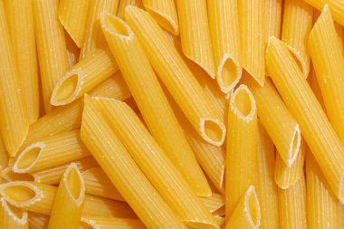 Pişmemiş Penne Rigate Makarnası: Gurme Aşçılık İçin Canlı ve Dokulu Bir Arkaplan Oluşturan Penne Makarna Mutfağı. Kuru makarna. Raw Macaroni - Top View, Düz Yat