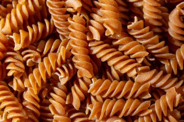 Pişmemiş Whole Grain Fusilli Makarna: Gurme Aşçılık İçin Canlı ve Dokulu Bir Arkaplan Oluşturan Tam Buğday Büfesi. Tam Tahıllı Kurutulmuş Makarna. Tam buğday hamurlu makarna.