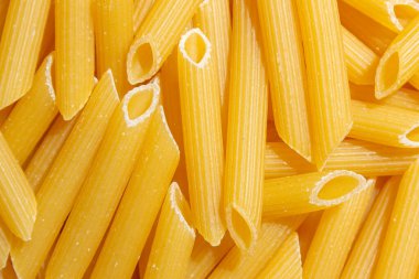 Pişmemiş Penne Rigate Makarnası: Gurme Aşçılık İçin Canlı ve Dokulu Bir Arkaplan Oluşturan Penne Makarna Mutfağı. Kuru makarna. Raw Macaroni - Top View, Düz Yat