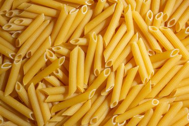 Pişmemiş Penne Rigate Makarnası: Gurme Aşçılık İçin Canlı ve Dokulu Bir Arkaplan Oluşturan Penne Makarna Mutfağı. Kuru makarna. Raw Macaroni - Top View, Düz Yat