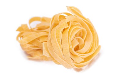 İki klasik İtalyan çiğ yumurtası Fettuccine - Beyaz arka planda izole edilmiş. Kuru, bükülmemiş, pişmemiş makarna. İtalyan Kültür ve Mutfağı. Çiğ Altın Makarna Deseni - İzolasyon