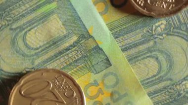 100 Euro 'luk banknotlara 20 Euro Cent madeni parası - Top View, Macro. Euro Para Birimi. Yeşil Kağıt Para. Yüz Euro 'luk banknot. İş, Finans, Para ve Tasarruf Konsepti - Dönüşüm Sola