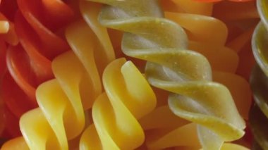 Pişmemiş Vibrant Renkli Fusilli Makarna: Büyüleyici bir rengarenk, desenli Arka plan Dönüşümlü Mutfak Kanvası. Renkli Kuru Makarnaya Dönüş. Çiğ makarna - Döndürme