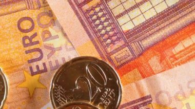 50 Euro 'luk banknotlara 20 Euro Cent madeni parası - Top View, Macro. Euro Para Birimi. Turuncu Kağıt Para. Bir sürü 20 Euro 'luk banknot. Ekonomi, Nakit ve Para Tasarruf Konsepti - Yavaş Dönüşüm Sola