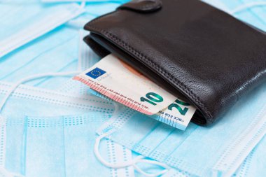 Black Mens Cüzdanı. Mavi Tek Kullanılabilir Tıbbi Yüz Maskeleri 'nin içinde Euro Para var. Tıbbi maske ticareti. Salgın ya da Salgın sırasında İş