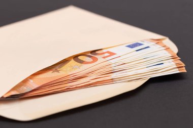 İçinde 50 Euro 'luk banknotlar olan bir Turuncu Kağıt Zarf. Nakit olarak maaş. Vergisiz sistem. Avrupa para birimi. Vergisiz ödemeler. Turuncu Kağıt Para. Bir sürü 50 Euro Fatura.