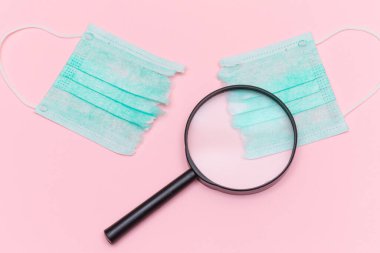 Anti Maske Hareketi - Yeşil Yırtık Tıbbi Maske Pembe Arkaplanda Büyüteç ile. Salgın ve Kilitlenme Sonu - Üst Görünüm, Düz Yat