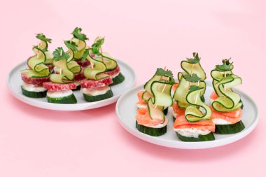 Taze somon, salam, salatalık, salatalık, yeşillik ve krem peynirli beyaz tabakta izole edilmiş kanepeler. Kolay Kahvaltı 'da. Diyet yemek. Hızlı ve sağlıklı sandviçler ve atıştırmalıklar.